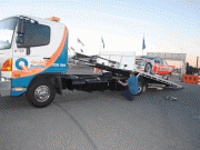 v8 supercar being loaded onto quality towing truck